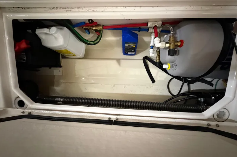 Slide: The Image of 2023 Ranger Tugs R-27 engine compartment with fluid containers and mechanical components. - 8