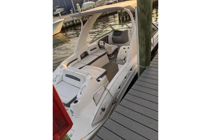 Slide: The Image of 2014 Chaparral 264 Sunesta boat docked, featuring spacious seating and sleek design. - 4