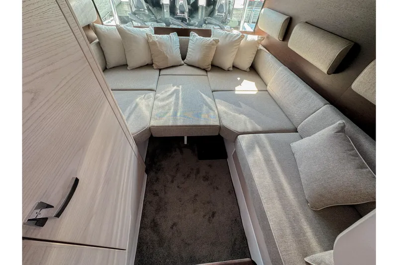 Slide: The Image of 2024 Axopar 45 XC Cross Cabin interior with cozy seating and cushions. - 12