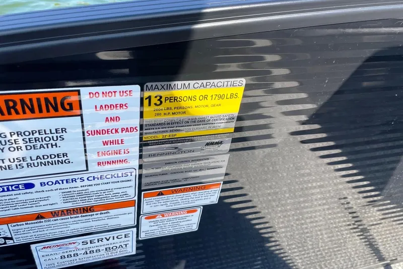 Slide: The Image of Warning labels on 2020 Bennington 22RSB boat, showing capacity and safety instructions. - 10