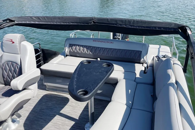 Slide: The Image of 2020 Bennington 22RSB pontoon boat interior with seating and table on water. - 9