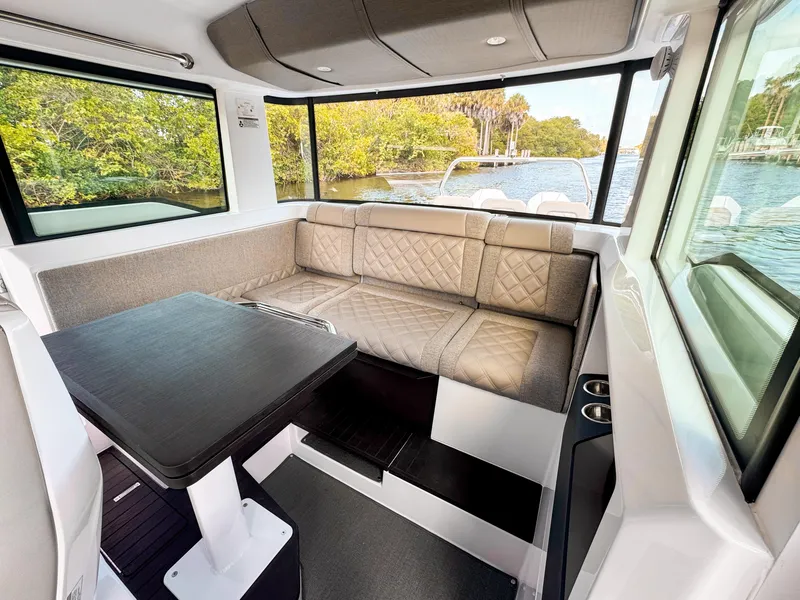 Slide: The Image of 2024 Axopar 37XC CROSS CABIN interior with plush seating and scenic water view. - 15