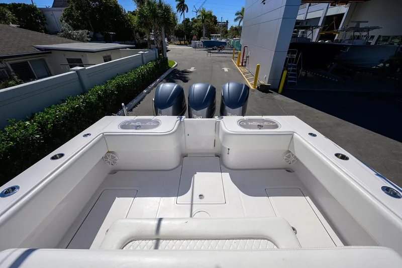 Slide: The Image of 2017 SeaHunter 33 Tournament boat with triple outboard engines, docked in a sunny marina. - 22