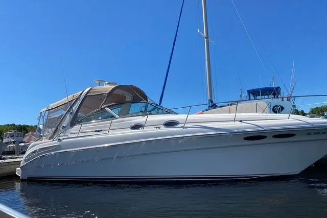 The Image of 2001 Sea Ray 340 Sundancer boat docked on calm water under clear blue sky. - 0