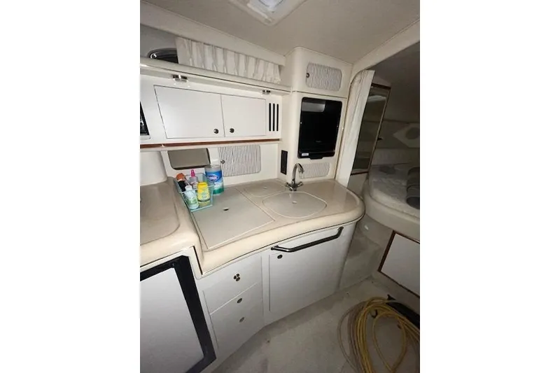 Slide: The Image of Interior of 2001 Sea Ray 340 Sundancer yacht with kitchenette and storage cabinets. - 10