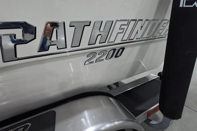 Slide: The Image of 2026 Pathfinder 2200 TRS boat logo on a trailer in a showroom. - 23