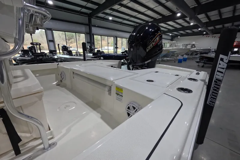 Slide: The Image of 2026 Pathfinder 2200 TRS boat interior with motor, showcased in a spacious showroom. - 5