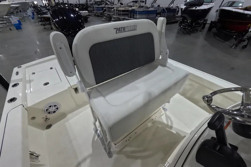Slide: The Image of 2026 Pathfinder 2200 TRS boat interior with seating and steering wheel in showroom. - 8