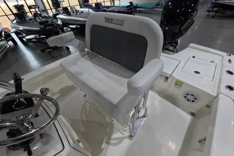 Slide: The Image of 2026 Pathfinder 2200 TRS boat interior with steering wheel and seating in showroom. - 9