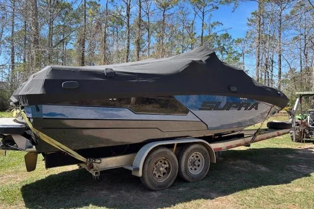 Slide: The Image of 2024 Supra SE 550 boat on trailer, covered, parked outdoors. - 3