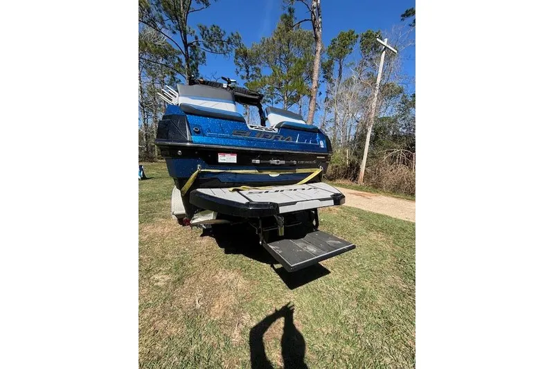 Slide: The Image of 2024 Supra SE 550 boat rear view on grass, showcasing swim platform. - 4