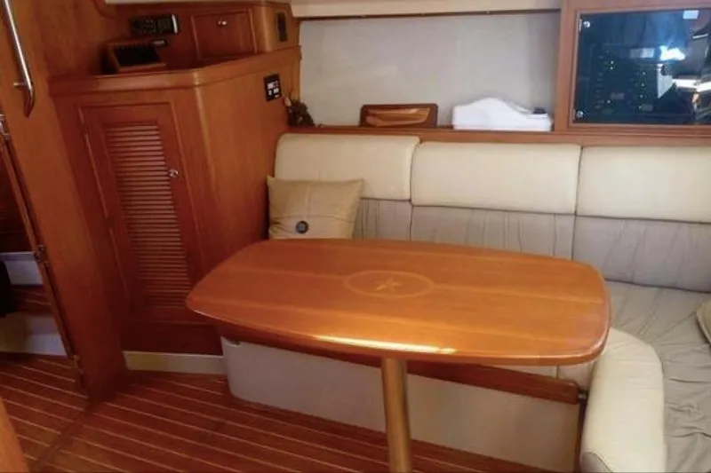 Slide: The Image of Interior of 2002 Island Packet Craft Express 360 with wooden table and cushioned seating. - 22
