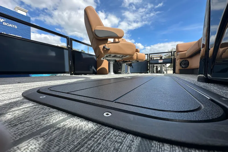 Slide: The Image of 2026 Ranger Reata 223FC boat interior with tan seating and sleek flooring under a blue sky. - 15