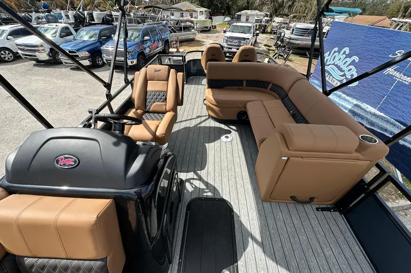 Slide: The Image of 2026 Ranger Reata 223FC boat interior with tan seating and steering console. - 16
