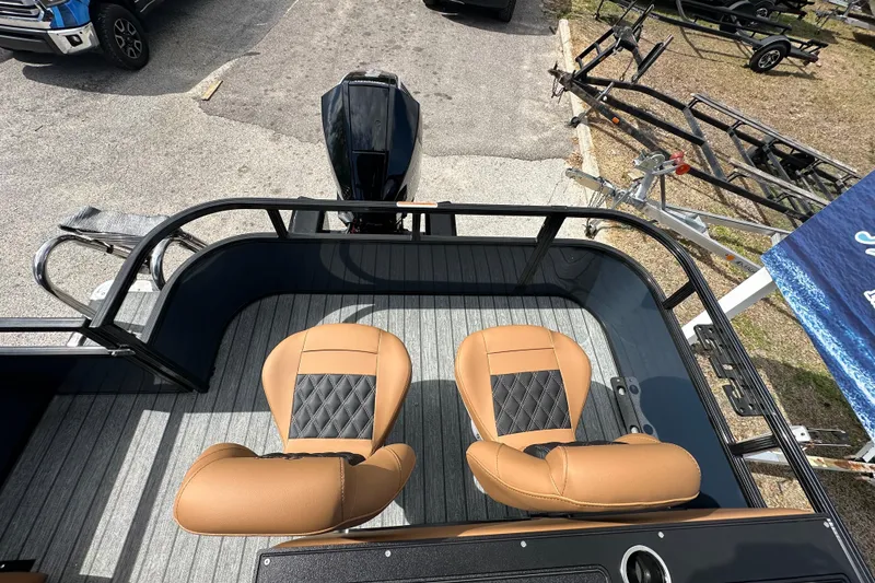 Slide: The Image of 2026 Ranger Reata 223FC boat interior with tan seats and motor, parked on trailer. - 18