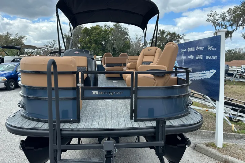 Slide: The Image of 2026 Ranger Reata 223FC pontoon boat with tan seating, displayed outdoors. - 3