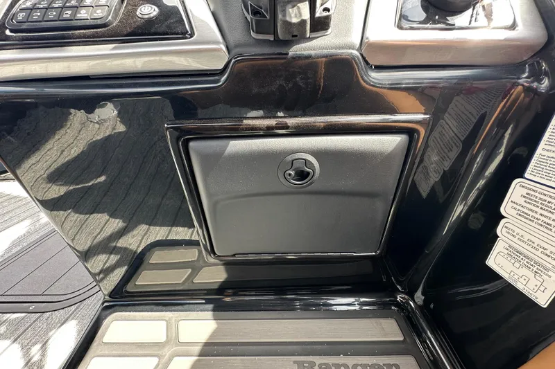 Slide: The Image of 2026 Ranger Reata 223FC boat dashboard with control panel and storage compartment. - 31