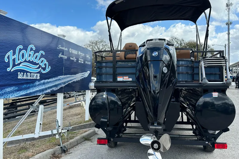 Slide: The Image of 2026 Ranger Reata 223FC boat at Holiday Marine dealership, rear view with outboard motor. - 42