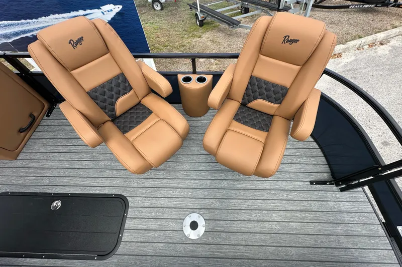 Slide: The Image of 2026 Ranger Reata 223FC boat seats, tan leather with diamond stitching, on a gray deck. - 8