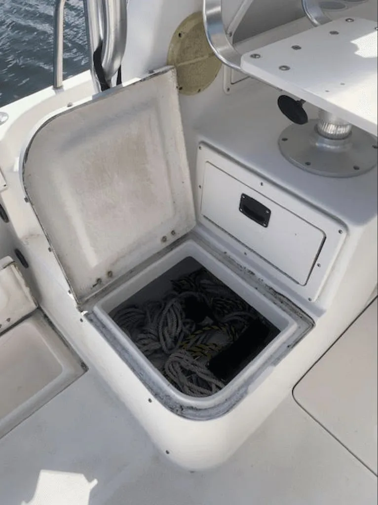 Slide: The Image of 2005 Robalo R235 WA boat with open storage compartment and ropes. - 13
