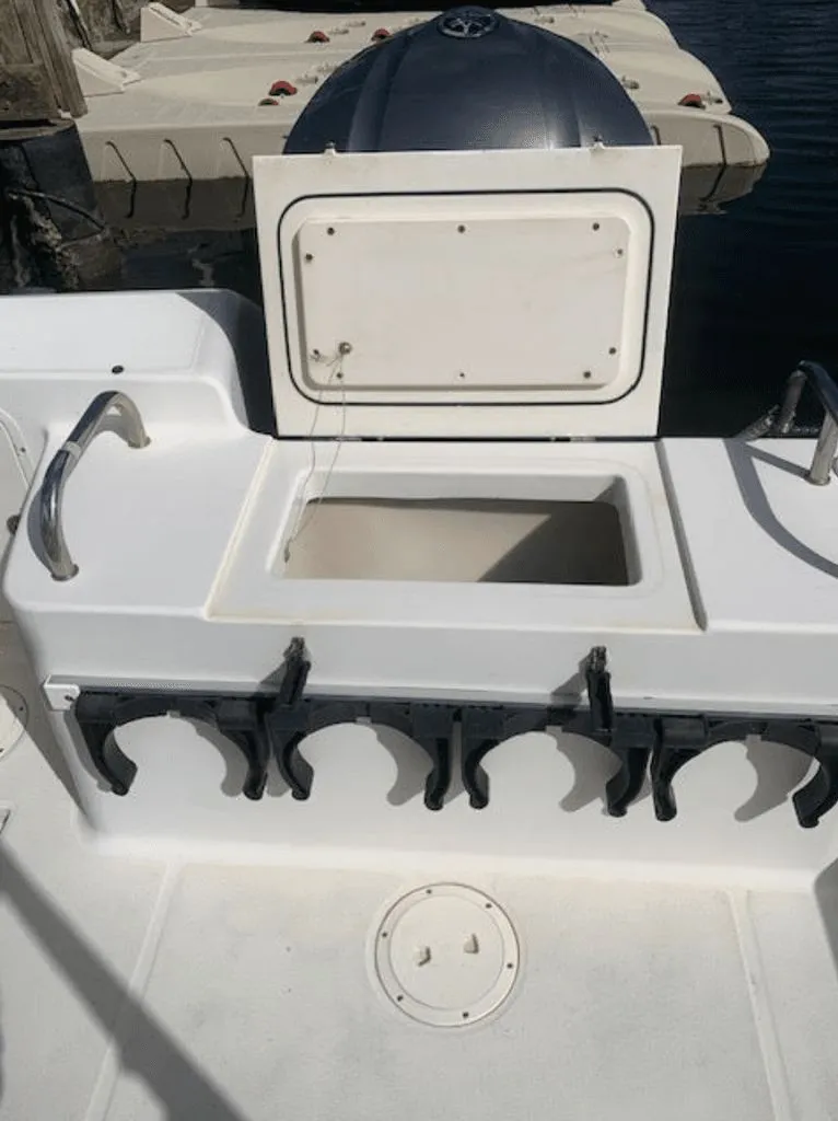 Slide: The Image of 2005 Robalo R235 WA boat with open storage compartment and rod holders. - 15