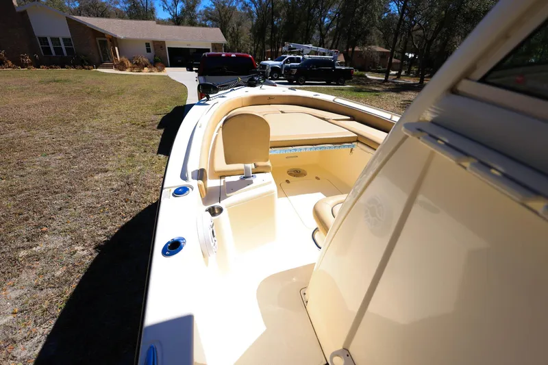 Slide: The Image of 2019 Scout 251 XSS boat interior with tan seating and fishing rod holders. - 15