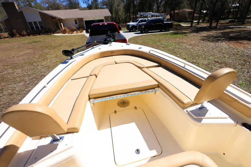 Slide: The Image of 2019 Scout 251 XSS boat parked in a residential driveway, showcasing interior seating. - 16