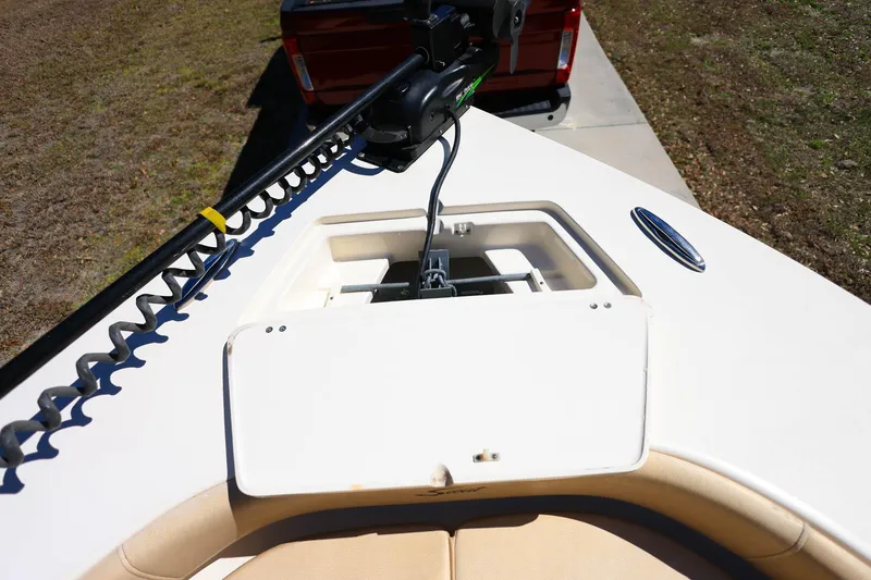 Slide: The Image of 2019 Scout 251 XSS boat interior with open storage compartment and tan seating. - 20