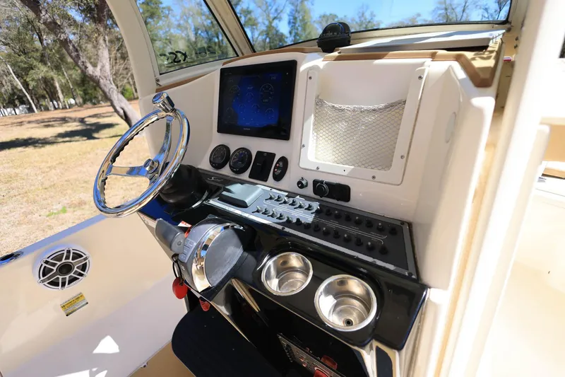 Slide: The Image of 2019 Scout 251 XSS boat interior with beige seating and Mercury engine. - 25