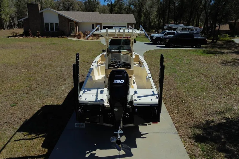 Slide: The Image of 2019 Scout 251 XSS boat on trailer in wooded area, side view. - 32