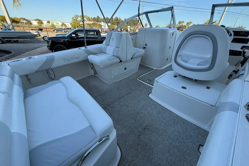 Slide: The Image of Interior of a 2011 Edgewater 205CX Crossover boat with white seating and carpeted floor. - 10