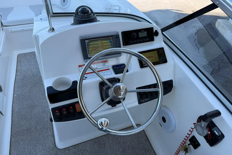 Slide: The Image of 2011 Edgewater 205CX Crossover boat dashboard with steering wheel and navigation controls. - 21