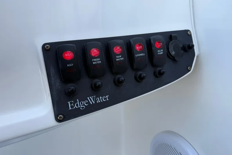 Slide: The Image of Control panel of 2011 Edgewater 205CX Crossover boat with labeled switches. - 24