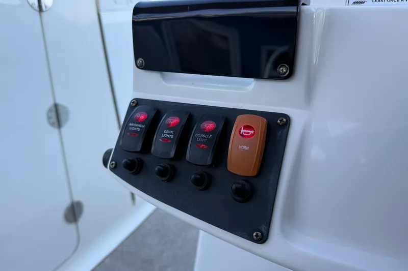 Slide: The Image of Control panel of 2011 Edgewater 205CX Crossover boat with labeled switches. - 25