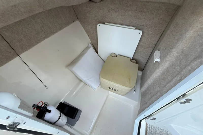 Slide: The Image of Interior of 2011 Edgewater 205CX Crossover boat with portable toilet and fire extinguisher. - 31