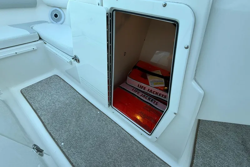 Slide: The Image of Storage compartment with life jackets on a 2011 Edgewater 205CX Crossover boat. - 33