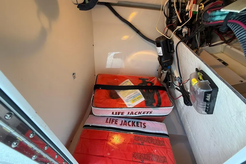 Slide: The Image of Storage compartment in a 2011 Edgewater 205CX Crossover with life jackets and wiring. - 34