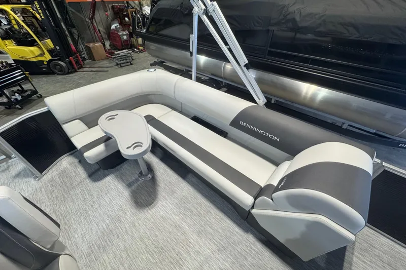 Slide: The Image of 2026 Bennington 20 S-One L-Bench pontoon boat interior with sleek seating and table. - 11