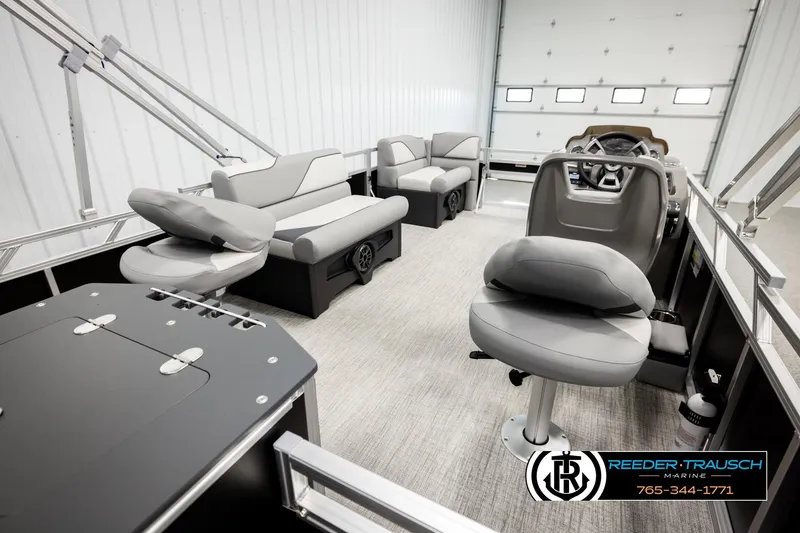 Slide: The Image of 2026 Avalon VEN RF boat interior with modern seating and steering console in a showroom. - 24