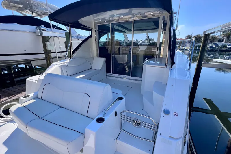 Slide: The Image of 2018 Cruisers Yachts 41 Cantius with sleek seating and modern design at a marina. - 14