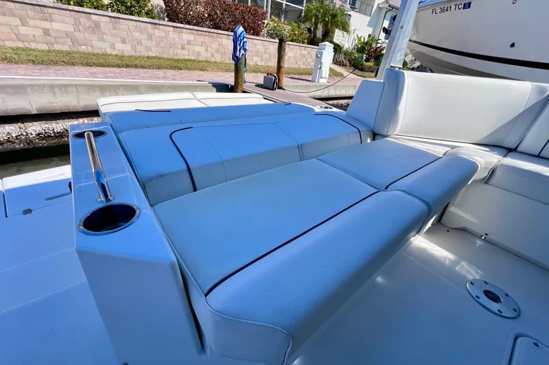 Slide: The Image of 2018 Cruisers Yachts 41 Cantius, luxurious seating area with cup holder, docked at marina. - 17