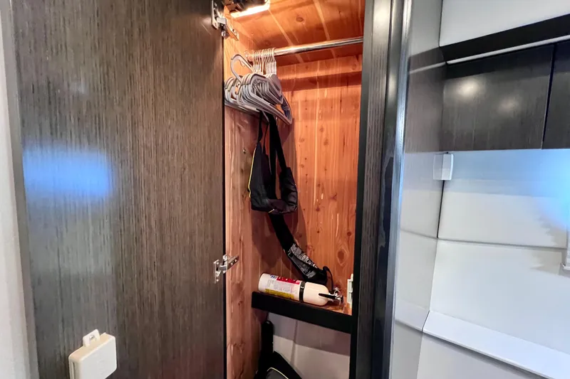 Slide: The Image of 2018 Cruisers Yachts 41 Cantius closet with hangers and fire extinguisher. - 63
