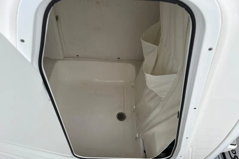 Slide: The Image of 2019 Tidewater 232 CC Adventure boat storage compartment with drain and curtain. - 27