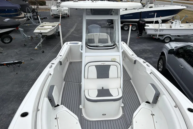 Slide: The Image of 2019 Tidewater 232 CC Adventure boat interior with seating and console, parked in a marina. - 5
