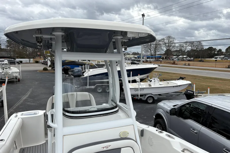 Slide: The Image of 2019 Tidewater 232 CC Adventure boat at a dealership, surrounded by other boats and vehicles. - 7