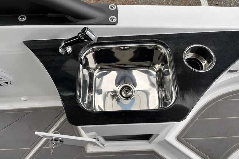 Slide: The Image of Stainless steel sink on 2026 Monterey Elite 25 OB boat with black countertop. - 13