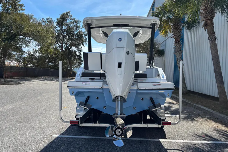 Slide: The Image of 2026 Monterey Elite 25 OB boat, rear view with outboard motor, parked outdoors. - 3