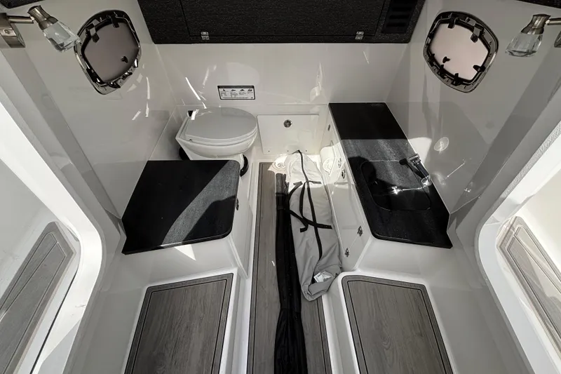 Slide: The Image of 2026 Monterey Elite 25 OB boat interior with toilet, sink, and storage compartments. - 35
