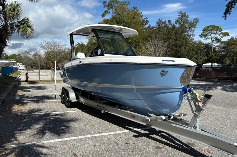 Slide: The Image of 2026 Monterey Elite 25 OB boat on trailer in sunny parking lot. - 6