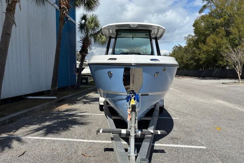 Slide: The Image of 2026 Monterey Elite 25 OB boat on trailer, parked outdoors under palm trees. - 7